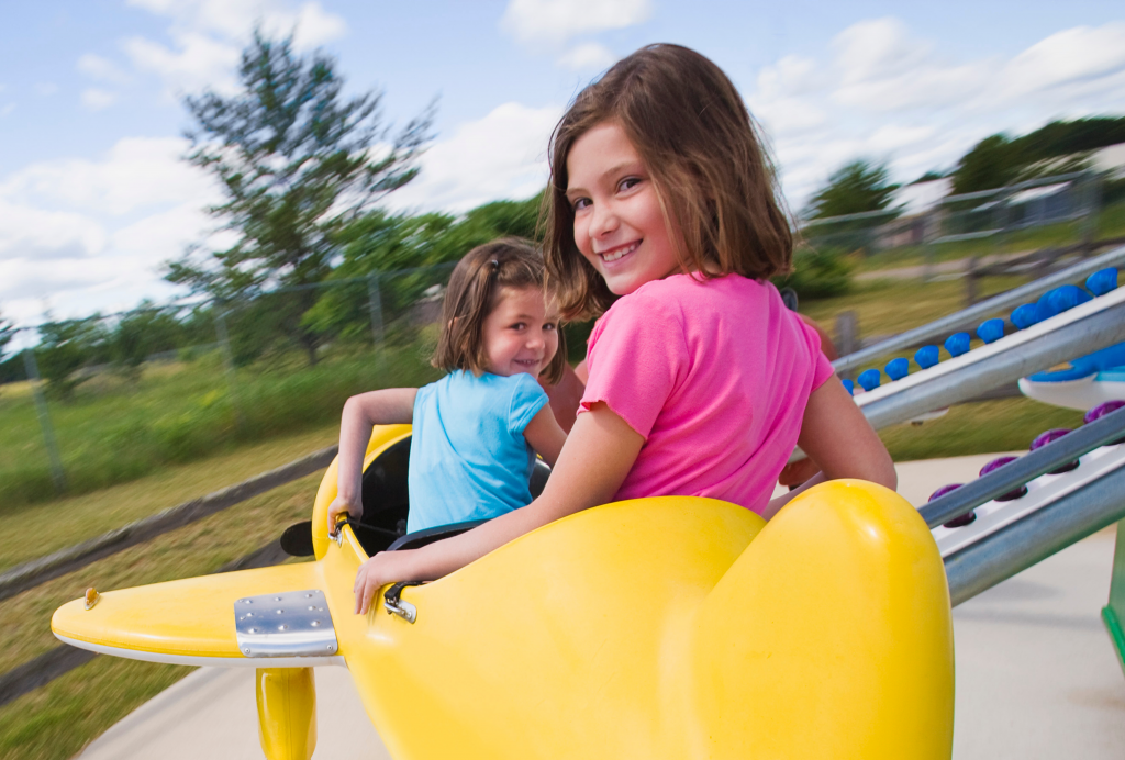 3 two children riding in theme park plane